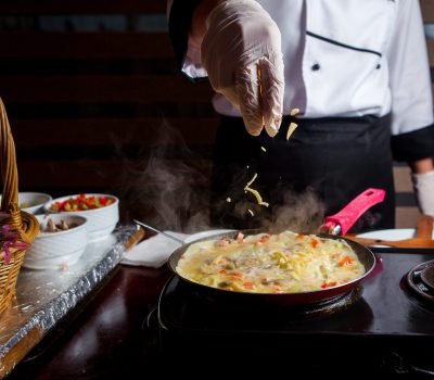 Chef preparing delicious meal in a kitchen side view